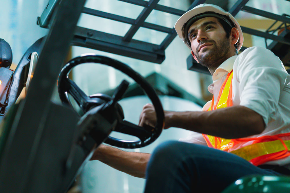 Professional forklift driver in a warehouse, highlighting the efficiency of a single logistics provider.